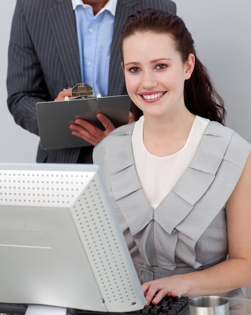 Smiling young businesswoman working at a computer 