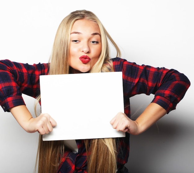 Smiling young casual style woman showing blank signboard, over white background isolated