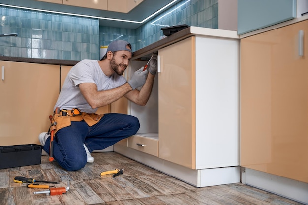 Smiling young caucasian home master working in kitchen