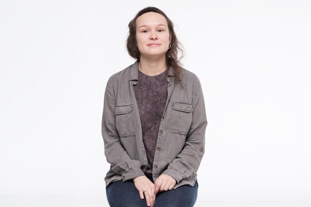 Smiling young caucasian woman sitting lookibn at camera