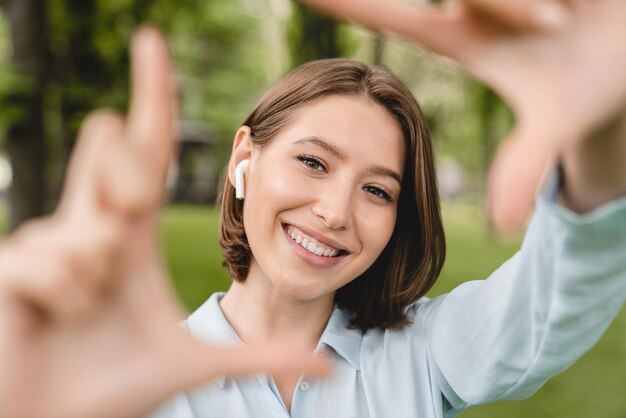 Smiling young caucasian woman teenager tutor teacher student taking selfie photo on her phone in city park outdoors Close up cropped portrait of a beautiful girl