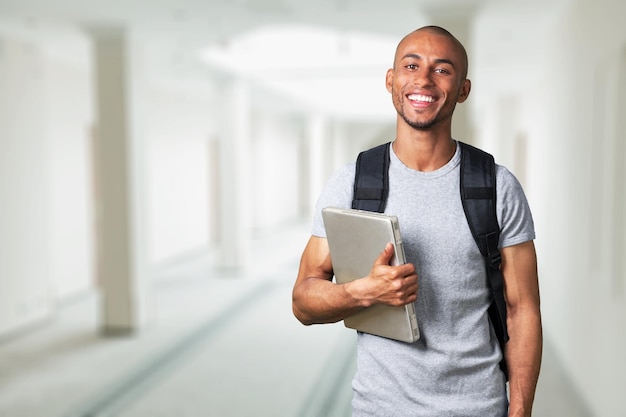 Smiling young college student with laptop