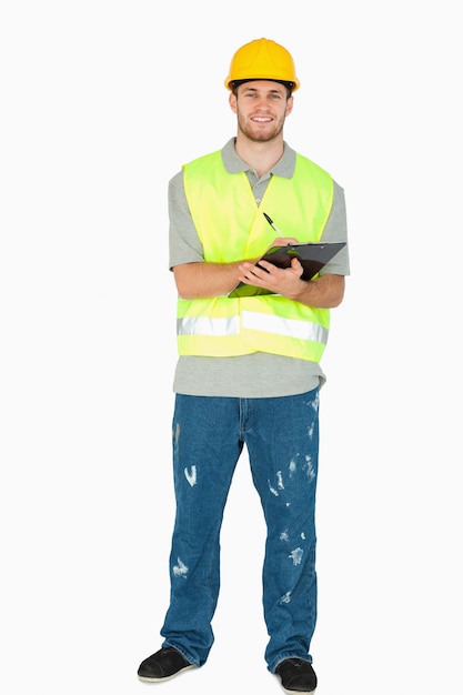 Smiling young construction worker taking notes