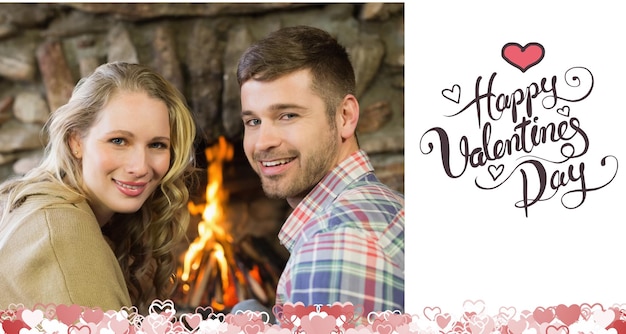 Smiling young couple in front of lit fireplace against happy valentines day