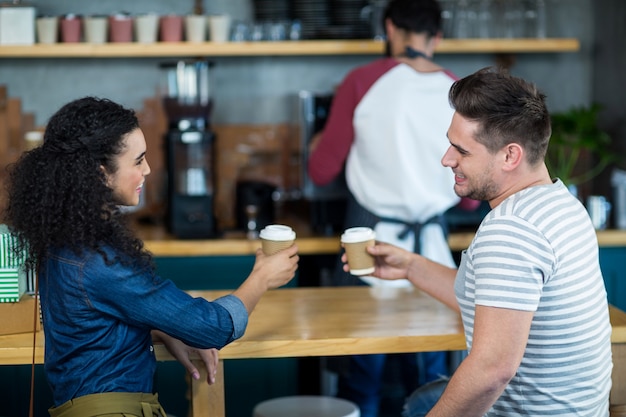 Smiling young couple having coffee in cafe