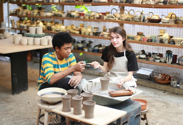 Smiling young couple in pottery workshop