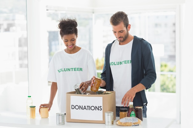 smiling young couple with donation box
