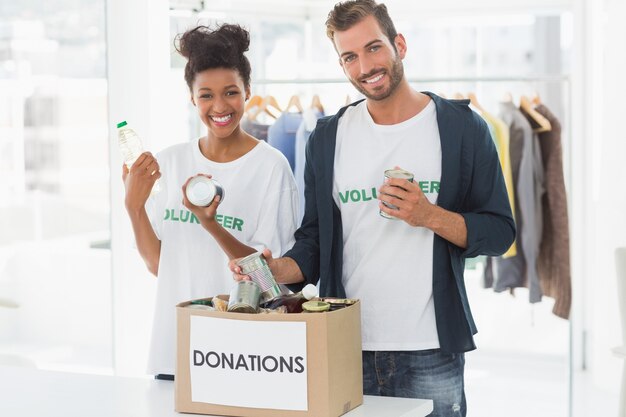 smiling young couple with donation box