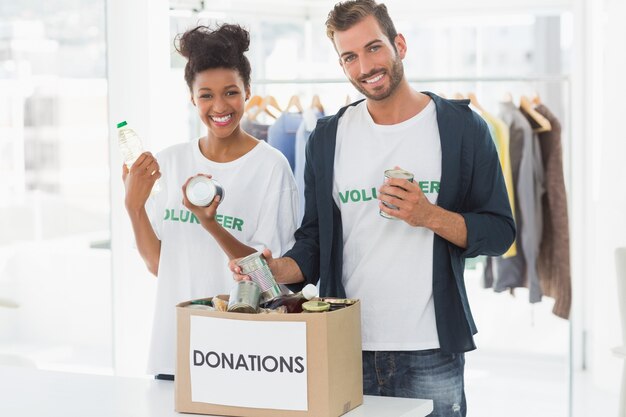 Photo smiling young couple with donation box