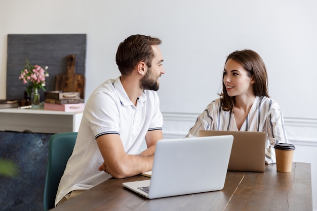 Smiling young couple working on a project while sitting at the desk at home