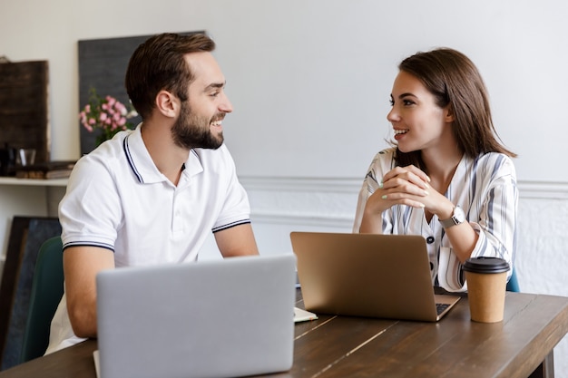 Smiling young couple working on a project while sitting at the desk at home