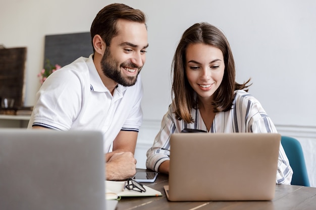 Smiling young couple working on a project while sitting at the desk at home