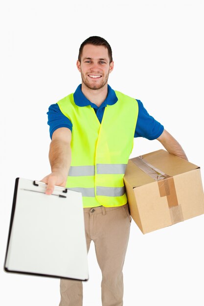 Smiling young delivery man handing over delivery note for signature