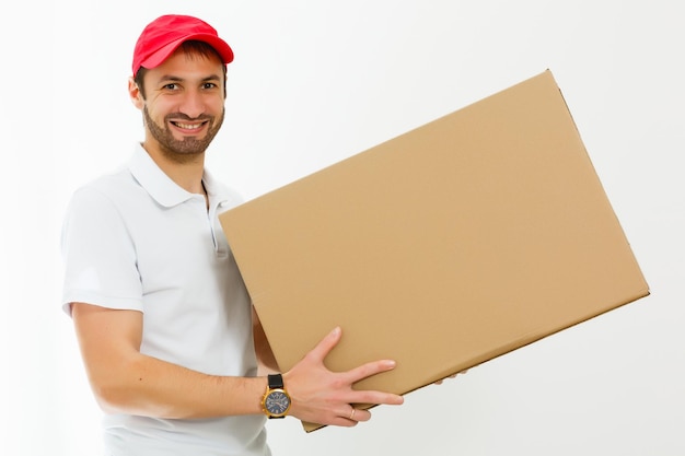 Smiling young delivery man holding and carrying a cardbox isolated on white background