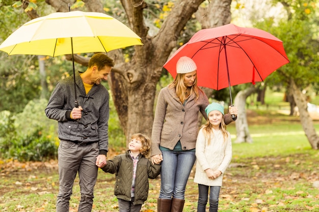 Улыбающаяся молодая семья под зонтиком