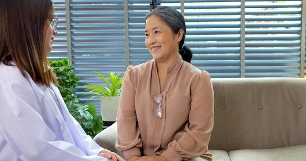 Smiling young female doctor enjoying conversation with happy senior woman