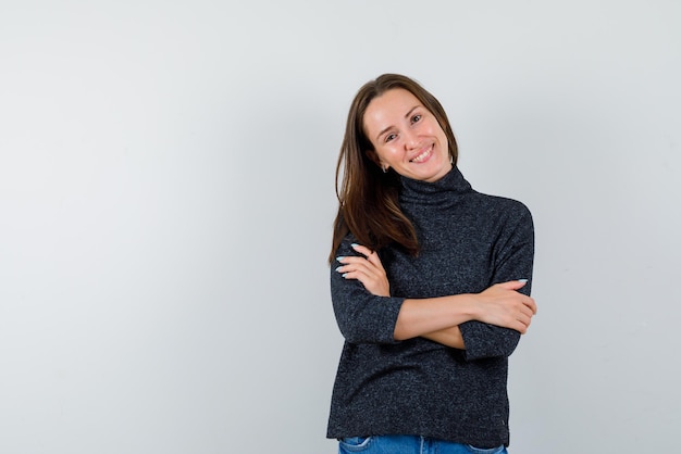 Smiling young girl crossing her arms on white background