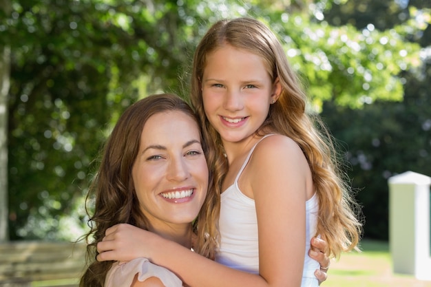 Smiling young girl and mother at park