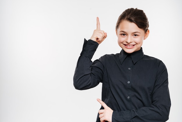 Smiling young girl posing and pointing