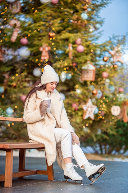 Smiling young girl skating on ice rink outdoors