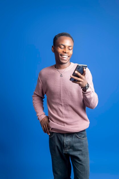 写真 スマートフォンを使って家族とコミュニケーションをとる笑顔の若い美しいアフリカ人男性