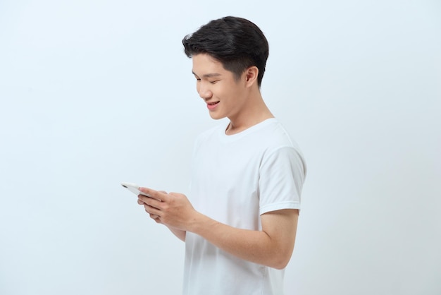 Smiling young good looking Asian man using smartphone to get in touch with family