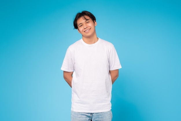 Smiling young guy standing casually blue background