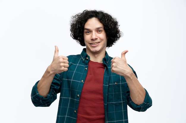 Photo smiling young handsome man looking at camera showing thumbs up isolated on white background