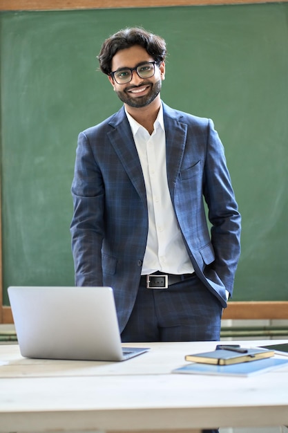 Photo smiling young indian business man wearing suit standing in office portrait