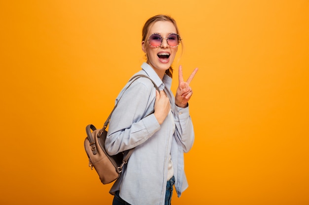 Smiling young lady with peace gesture.