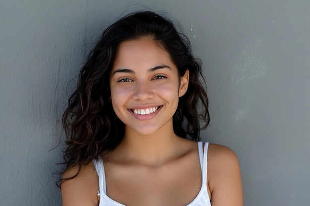smiling young latin woman with grey wall background