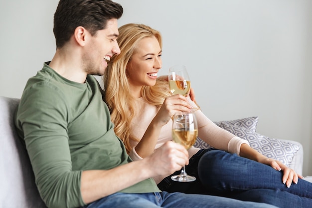 Smiling young loving couple drinking alcohol white wine champagne.