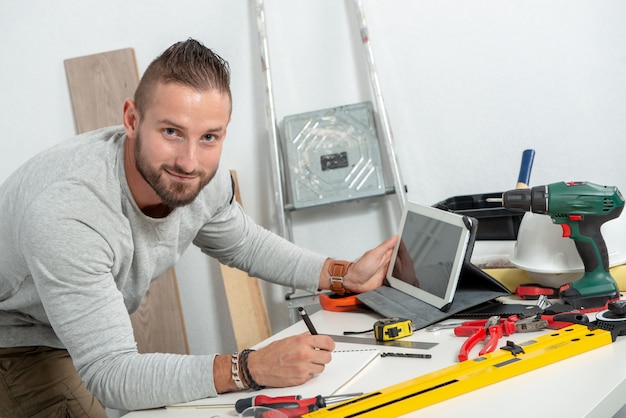 タブレットで自宅で笑顔若い男diy