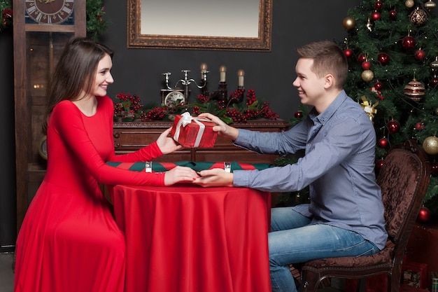 Smiling young man gives an attractive gift to beautiful woman.