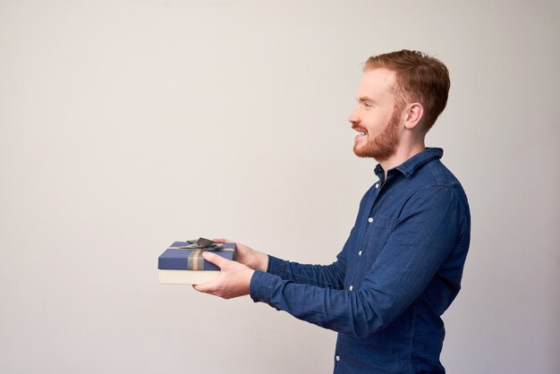 Smiling Young Man Giving Gift Box