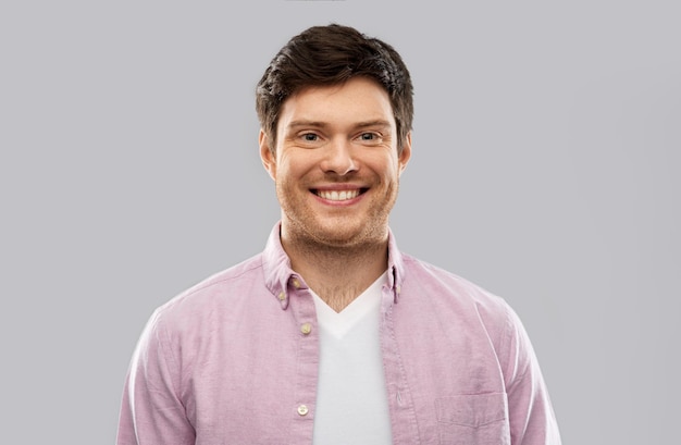 smiling young man over grey background