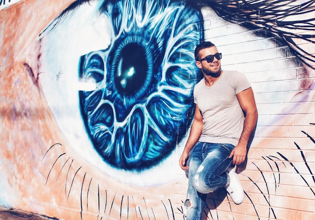 Smiling young man looking away against eye painting