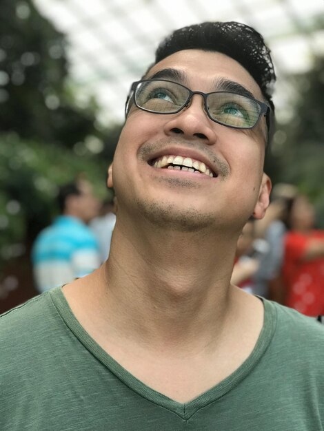 Photo smiling young man looking up outdoors