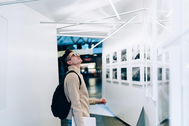 Smiling young man looking at wall in gallery