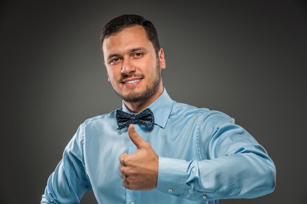 Foto giovane sorridente che fa il segno con la mano ok pollice in alto