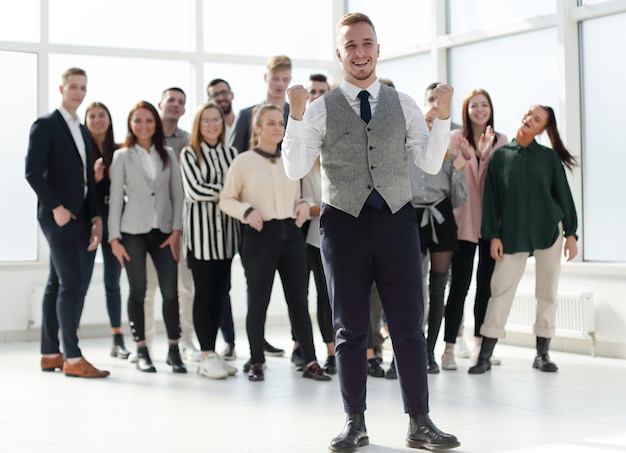 Smiling young man standing in front of his colleagues