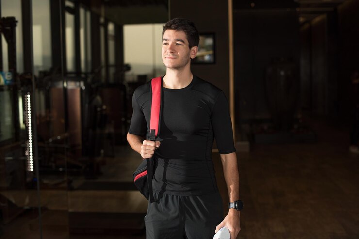 Photo ジムに立っている笑顔の若い男