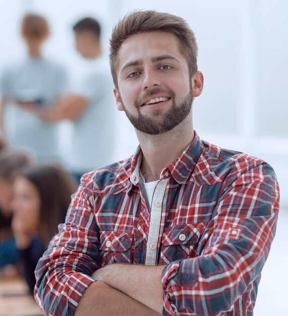 近代的なオフィスに立っている笑顔の若い男