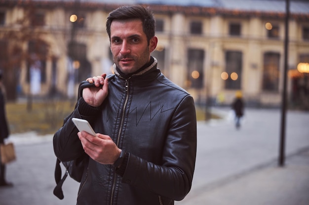 Smiling young man using cell phone outdoors