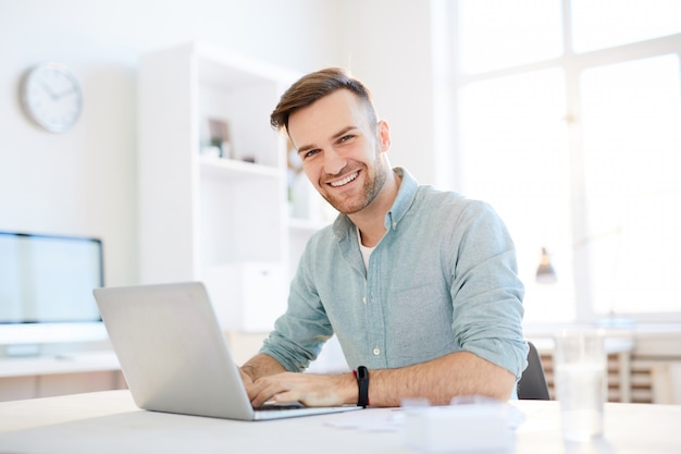 Smiling Young Man Using Laptop