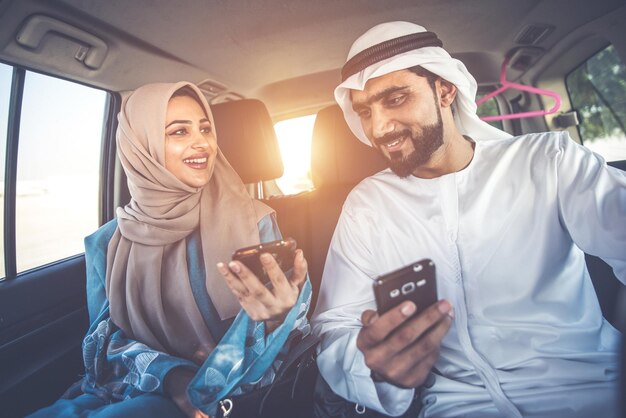 Foto giovane sorridente che usa il cellulare mentre è seduto sull'autobus