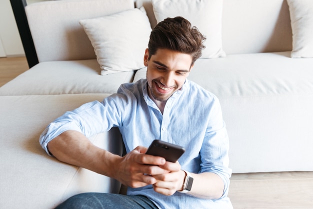 Smiling young man using mobile phone