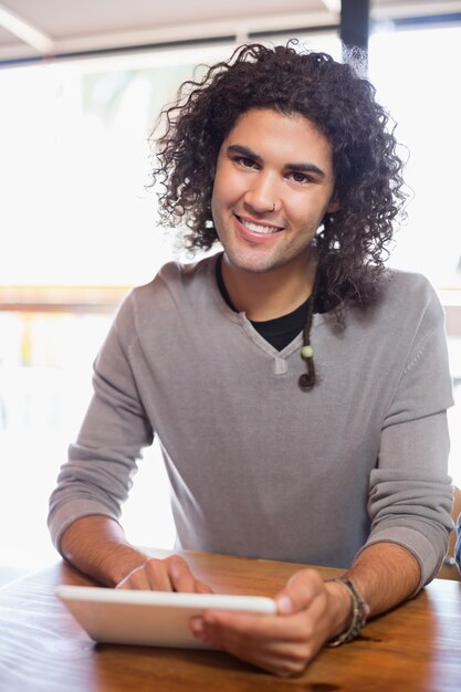 Giovane sorridente che utilizza tablet pc nel ristorante