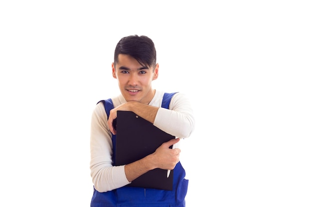 Smiling young man with dark hair wearing showing his black folder with white papers