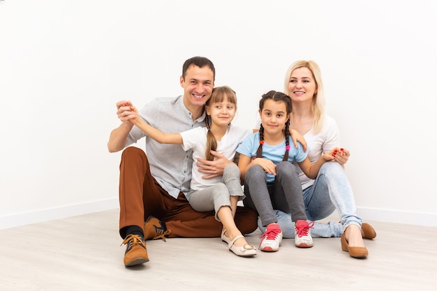 I giovani genitori sorridenti e i loro figli sono molto felici, sono a casa